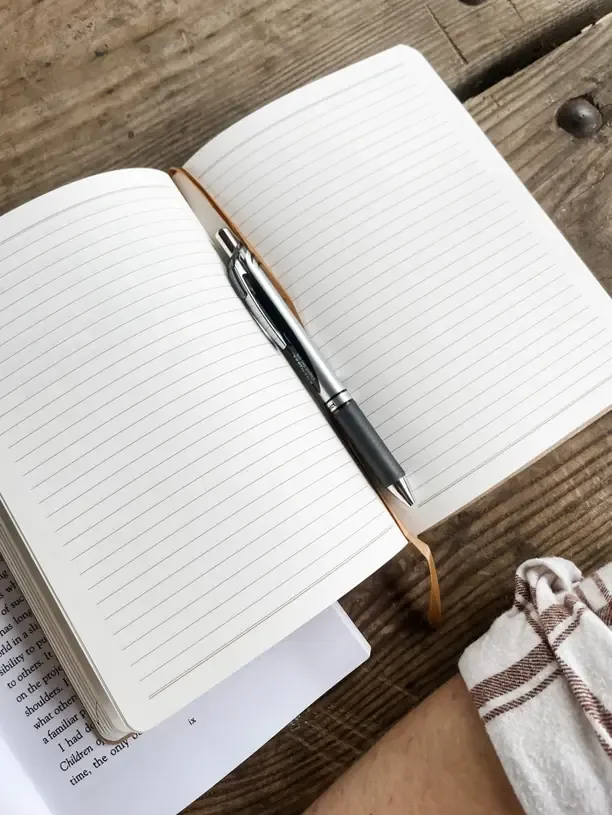 An open notebook with a pen, ready for your list of goals