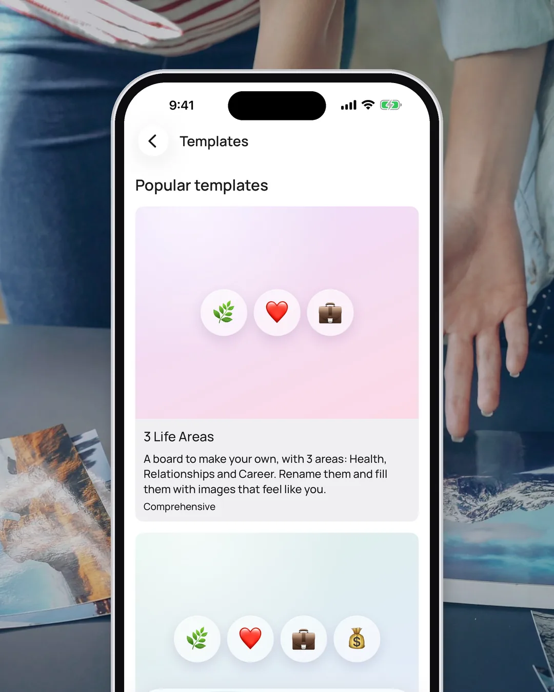 VISIYA's template gallery on an iPhone, showing Popular templates with the 3 Life Areas board at the top, framed over a photo of hands and printed pictures on a table