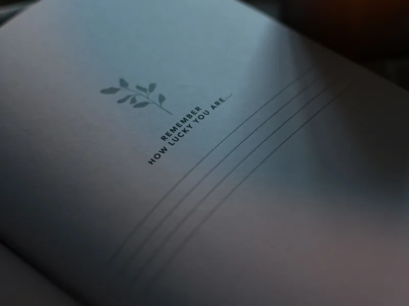 An open notebook in soft light with the words “Remember how lucky you are”