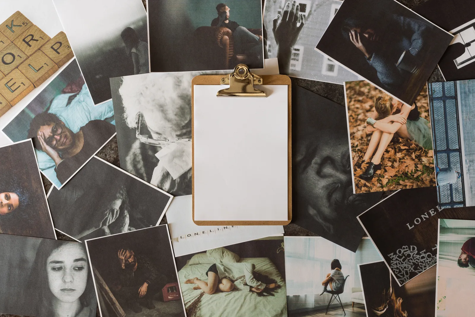Ein Flat-Lay aus gedruckten Fotos und Polaroids rund um ein leeres Klemmbrett, bereit für ein Vision Board
