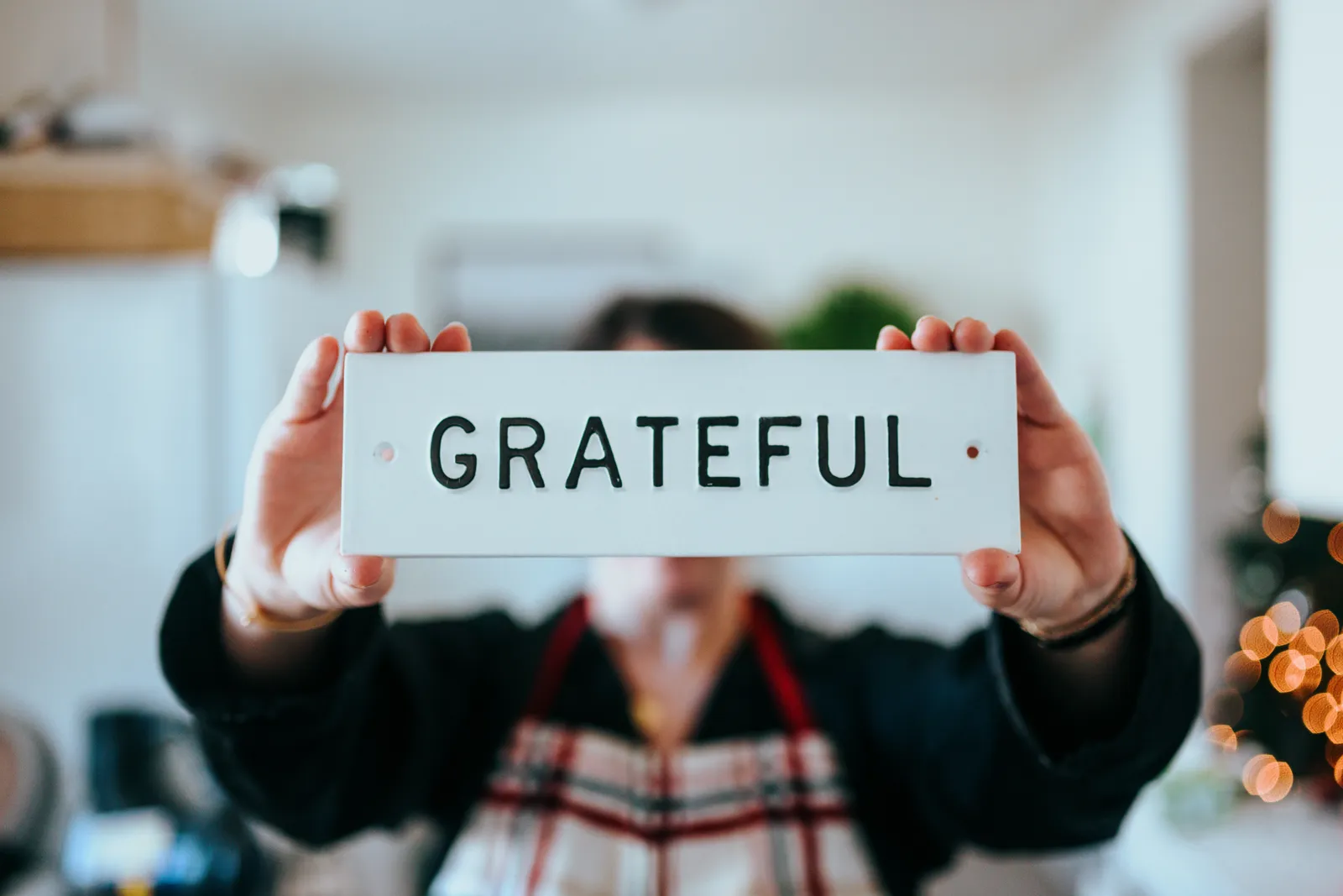 Руки держат табличку со словом «Grateful»