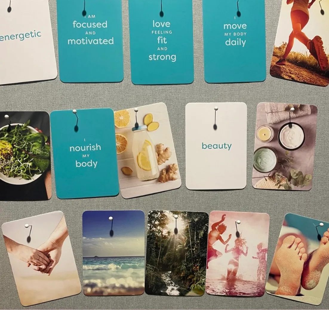 A set of vision board affirmation cards laid out with photos and phrases such as focused and motivated, nourish my body and beauty